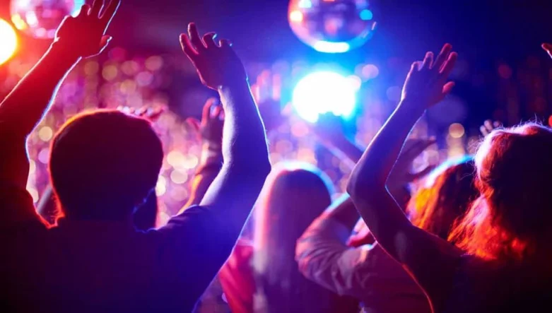 a-group-of-people-waving-their-arms-in-a-dance-club_971x551_1620996855
